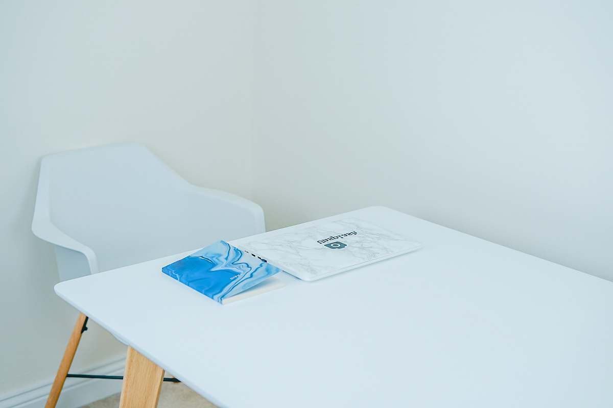 furniture blue covered book on white table with armchair in front united kingdom