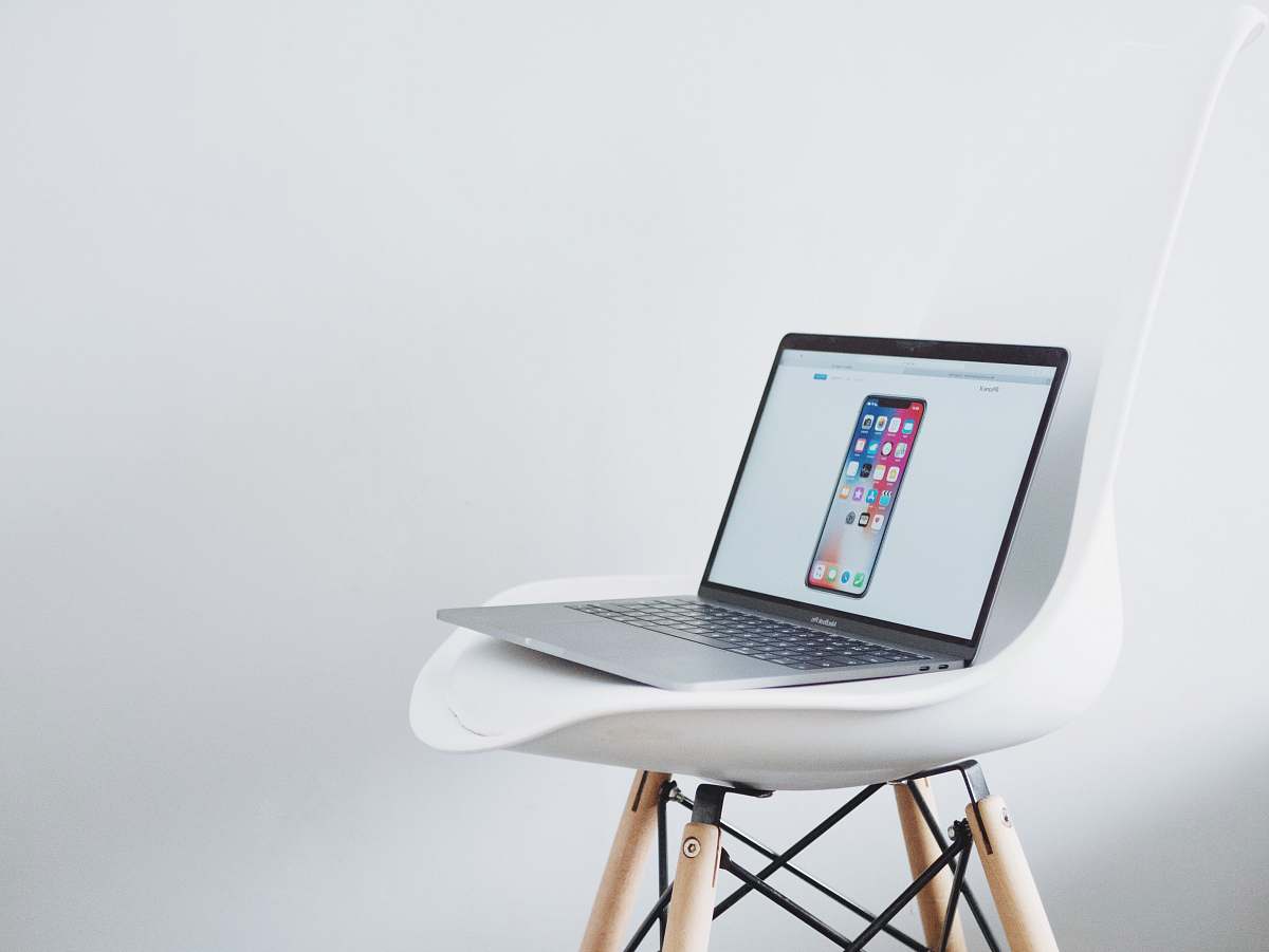 laptop turned on MacBook on top of white chair computer