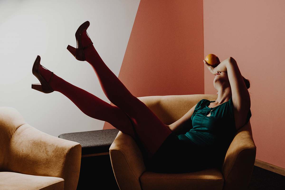 person woman sitting on brown armchair orange