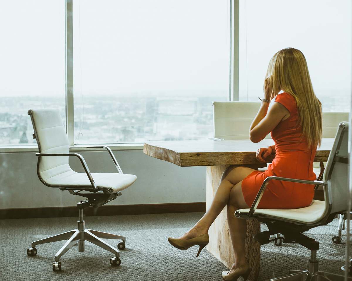 business woman talking through mobile phone while sitting on swivel armchair woman