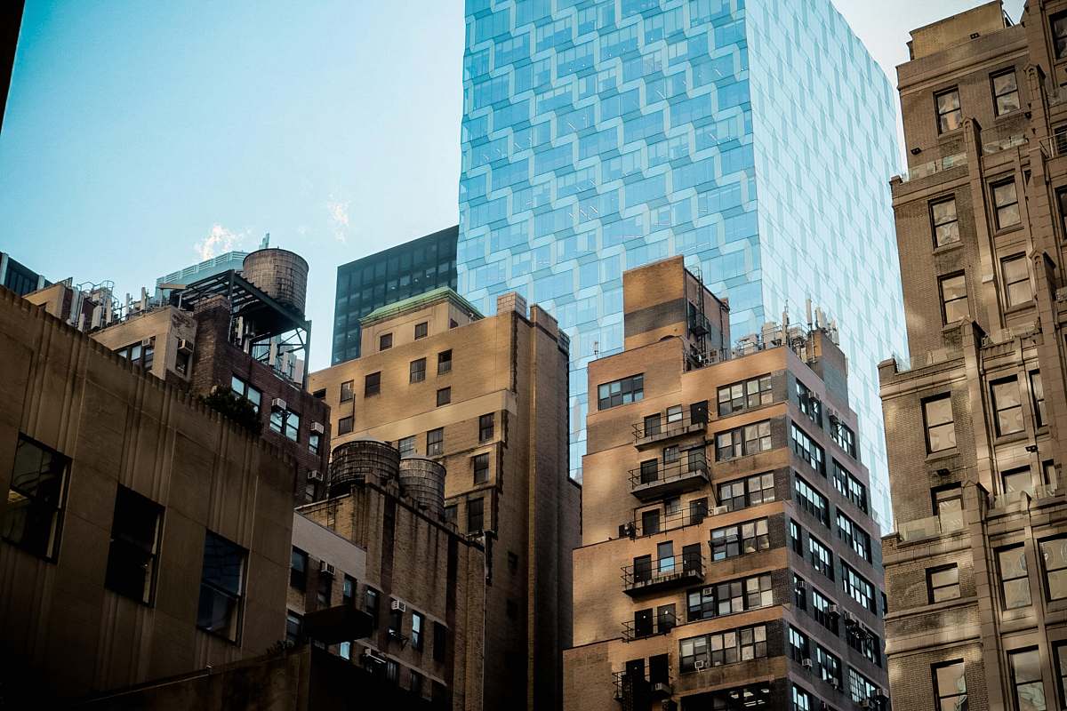 building brown concrete building across blue tall building high rise