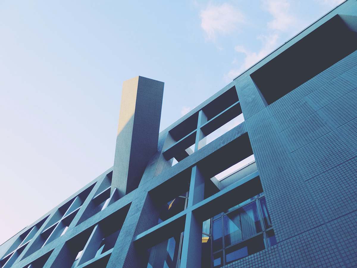 building low-angle photography of blue high-rise building under blue and white sky during daytime office building