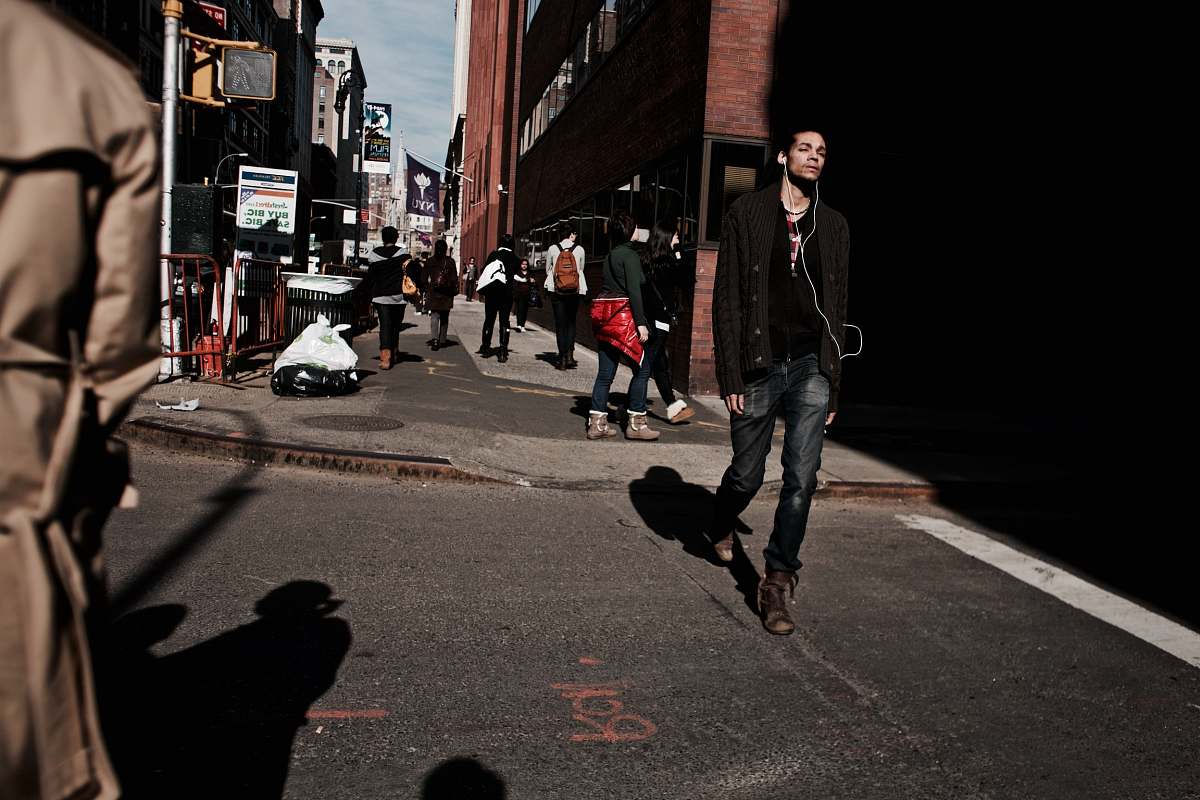 person man walking on road using earbuds people