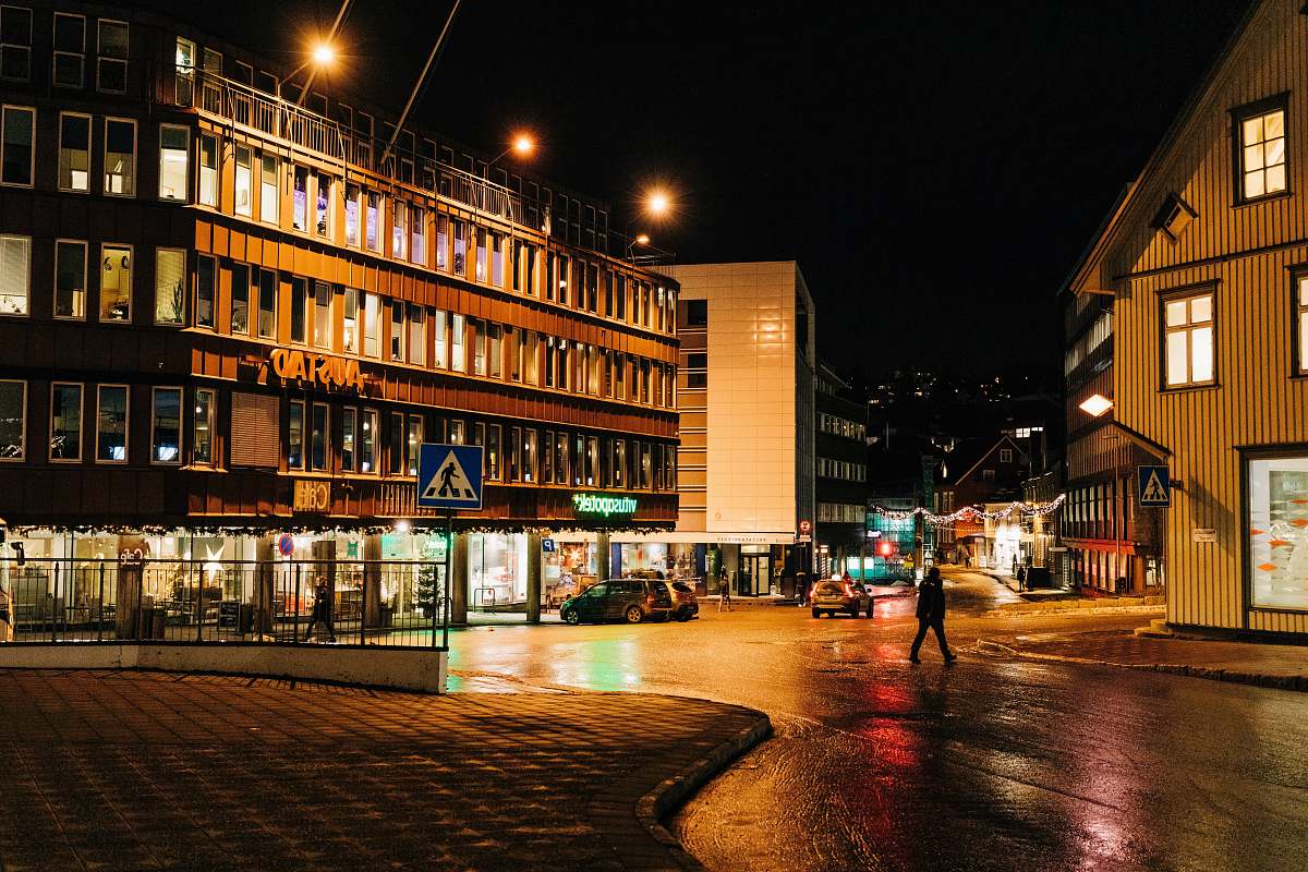 building person walking at road beside concrete building downtown