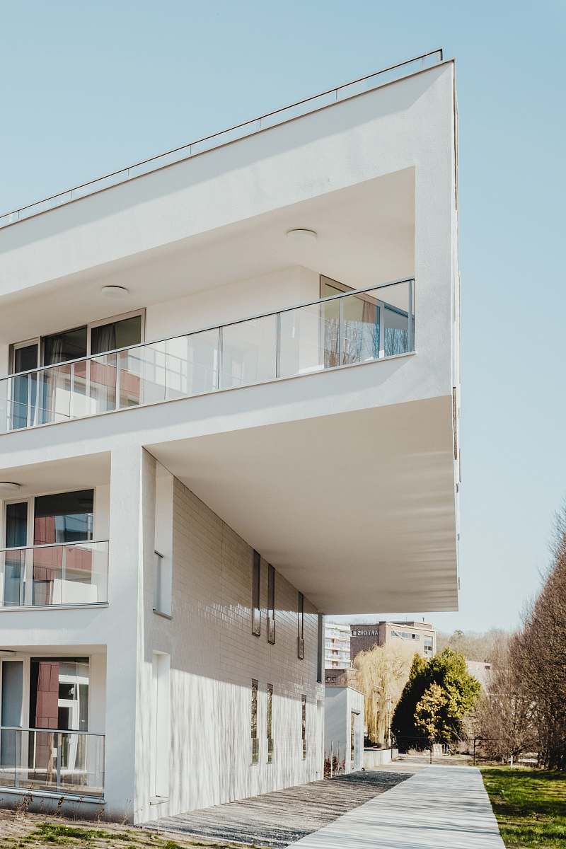 urban white concrete residential building near trees housing