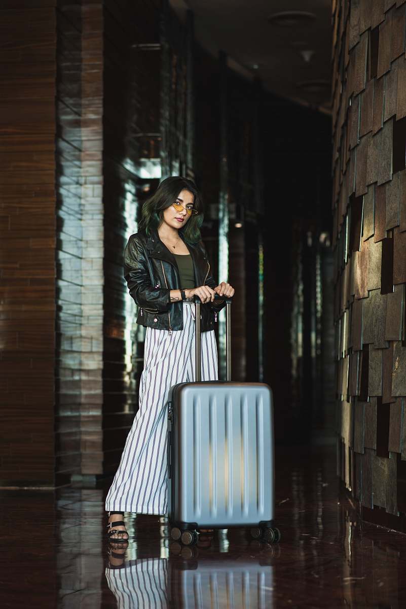 apparel standing woman front of luggage coat
