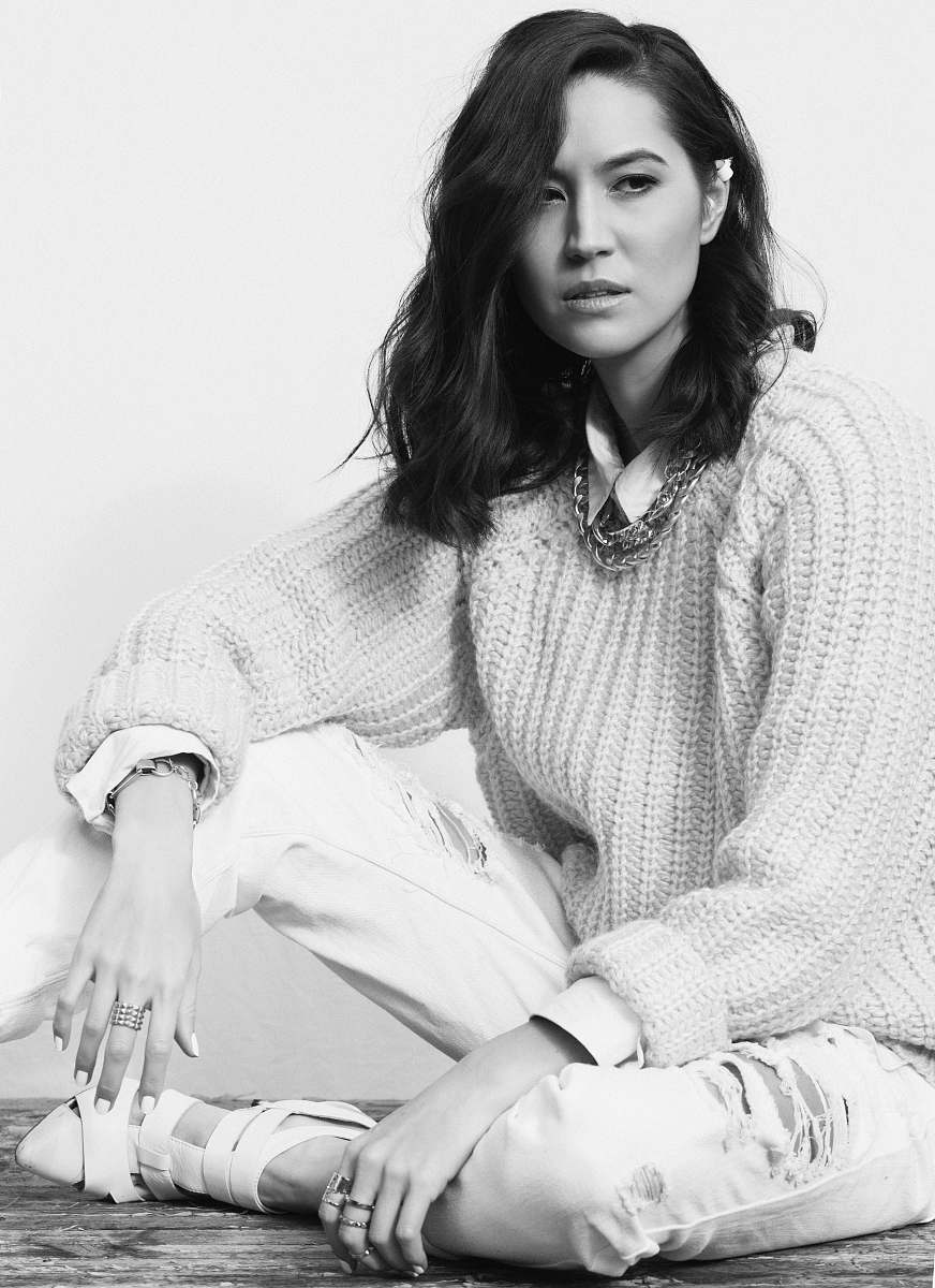 apparel woman in knit sweater and pants sits on parquet floor black-and-white
