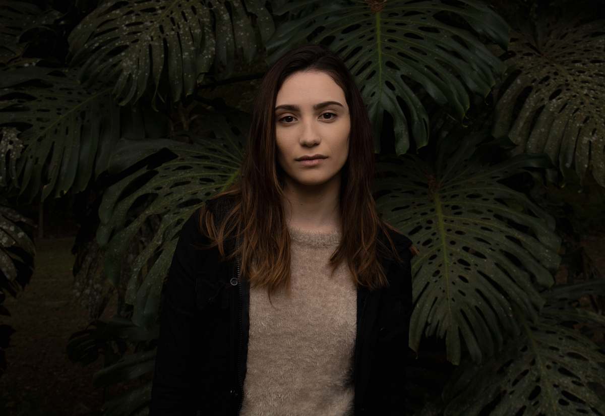 apparel woman standing in front of green leafed plants human