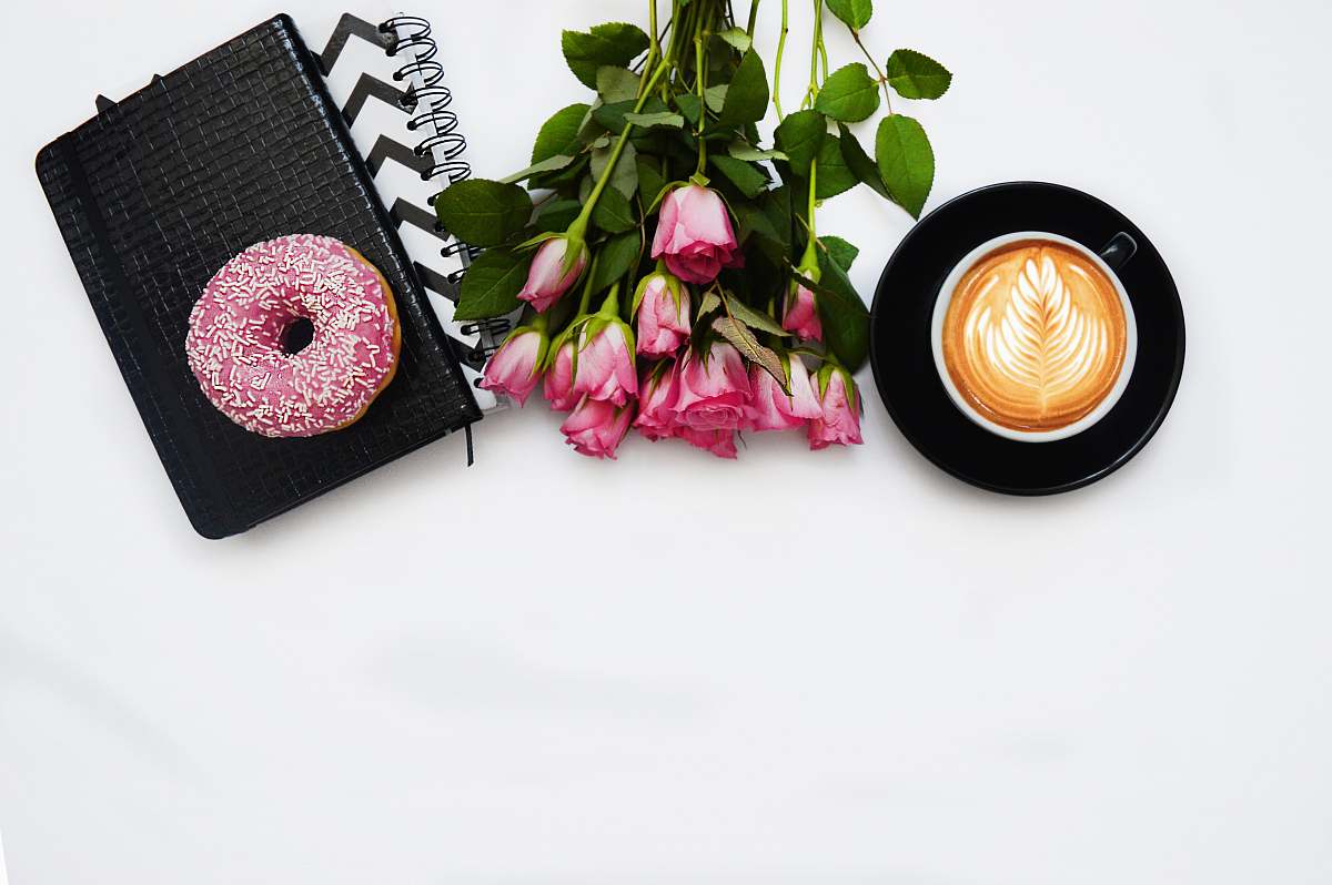 pink red rose flowers, pink dough nut graphic book and black ceramic cup kiev