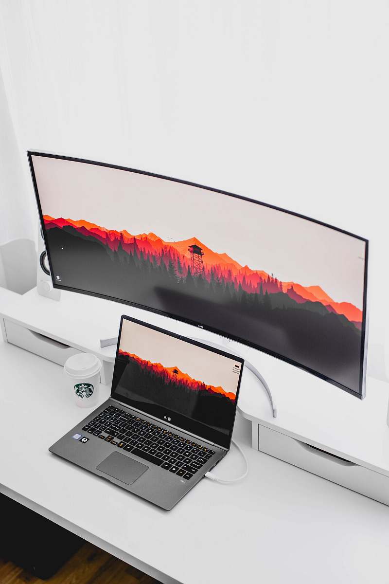 pc laptop computer beside curved monitor laptop