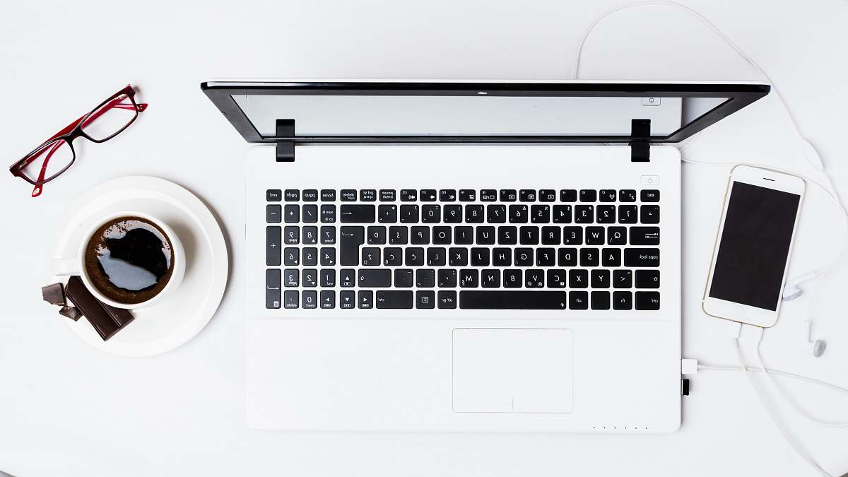 phone MacBook Pro between smartphone and teacup on white surface drink