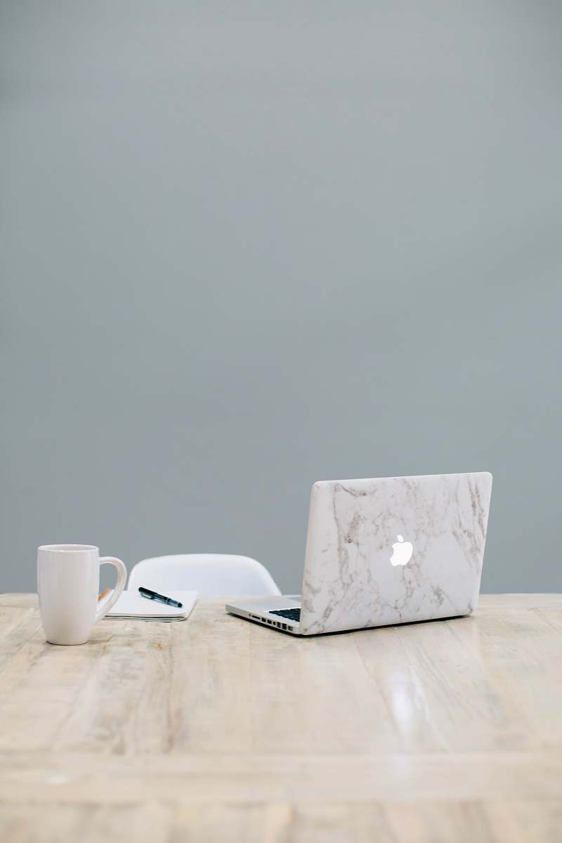 table MacBook on table near mug coffee table