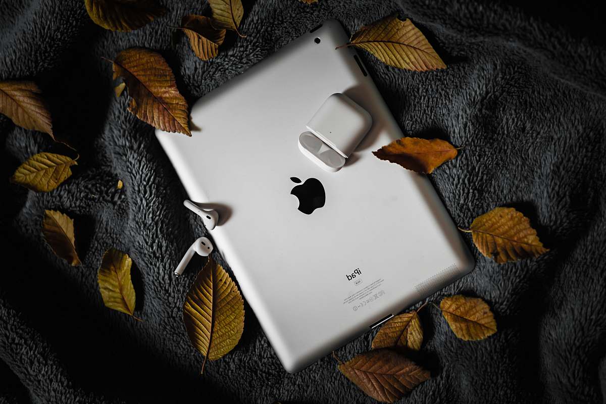 phone AirPods and charging case on iPad cell phone