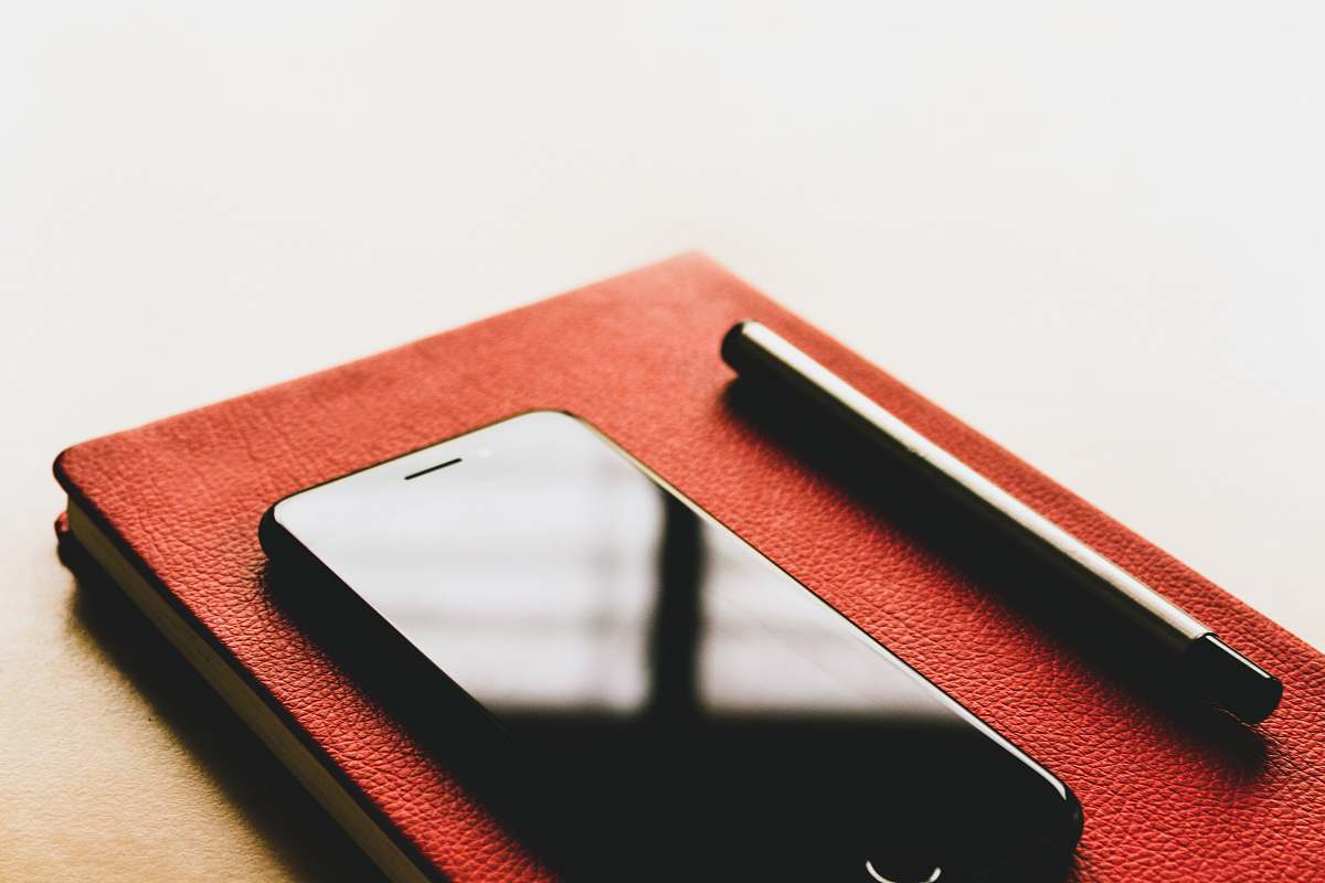 phone black iPhone on red book text