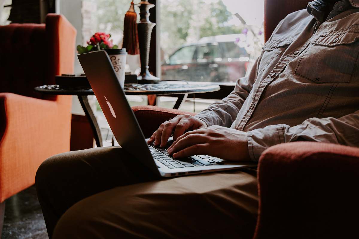 jar man sitting while using MacBook on lap plant