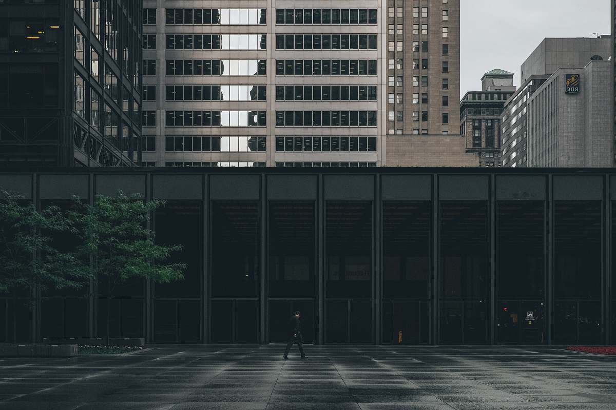 jar person walking near building during daytime plant