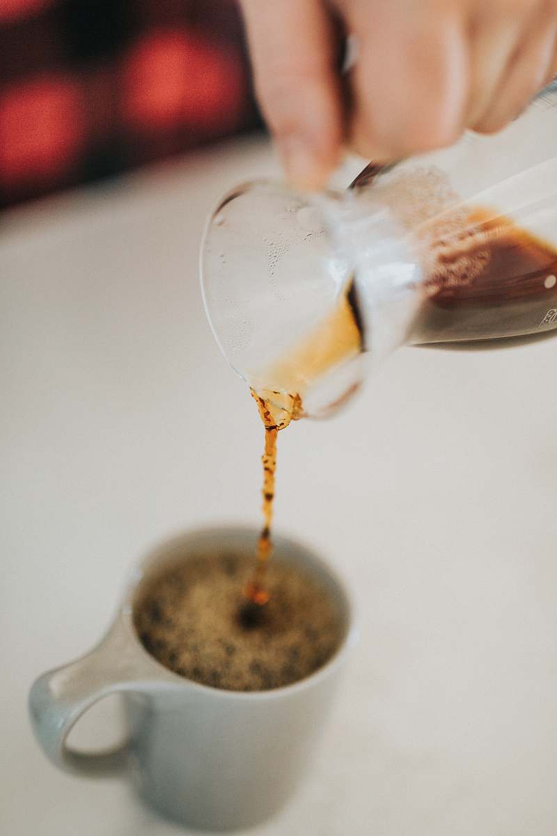 goblet person pouring coffee on gray up coffee
