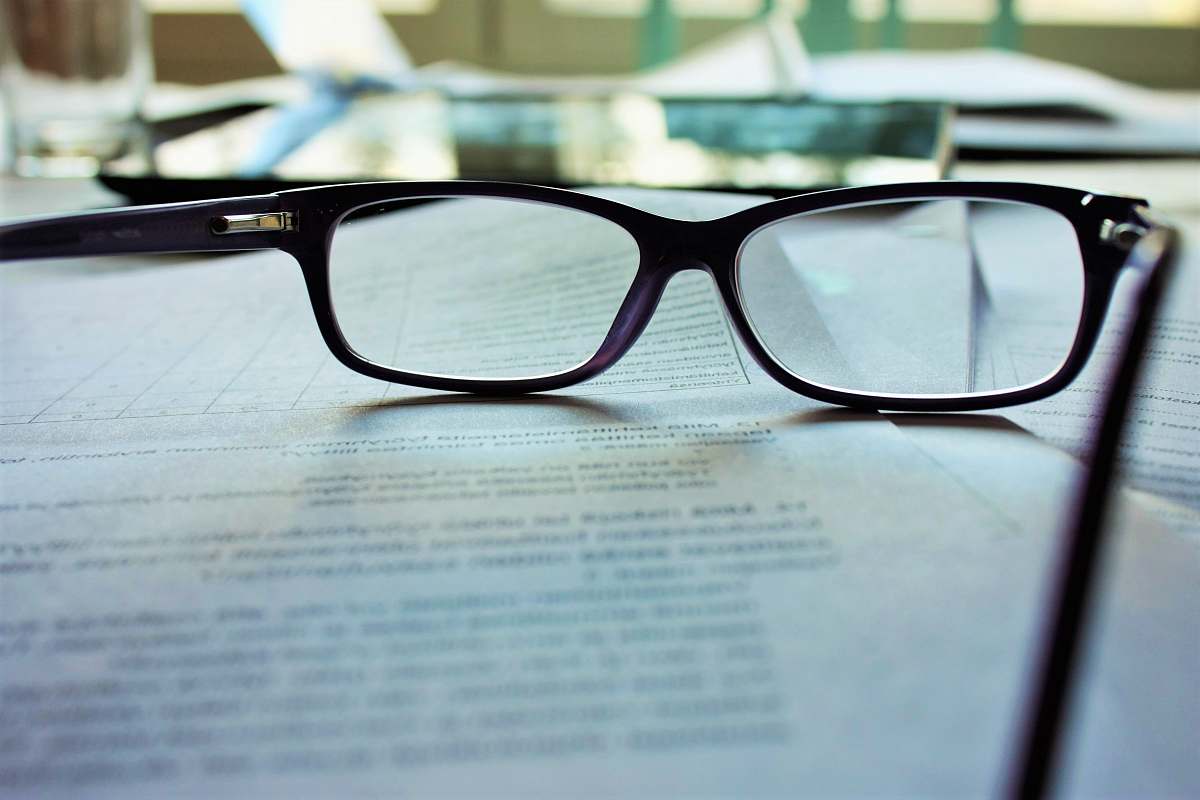 reading black-framed eyeglasses on white printing paper book