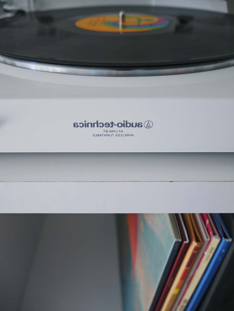file white Audio-Technica wireless turntable near vinyl record sleeve record