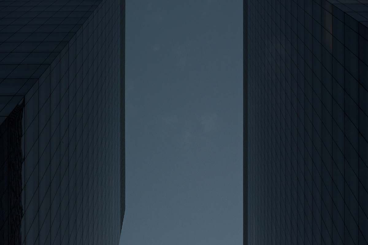 This stunning worm's eye view captures a couple walking hand in hand along a bustling city street, framed by towering skyscrapers that stretch towards the sky. The perspective emphasizes the grandeur of the urban landscape, making it an ideal image for real estate, travel blogs, or lifestyle publications. Perfect for conveying themes of love, adventure, and the vibrancy of city life.