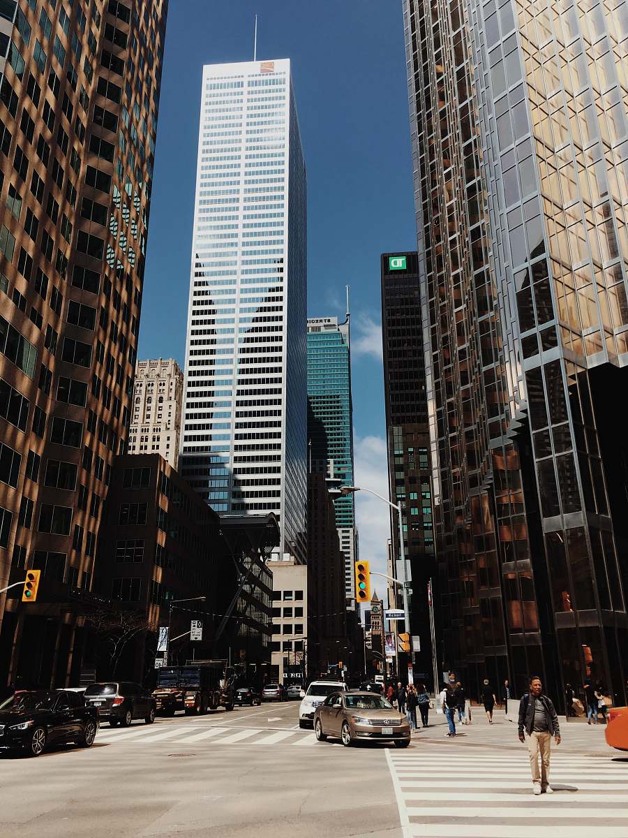 person cars crossing near buildings city