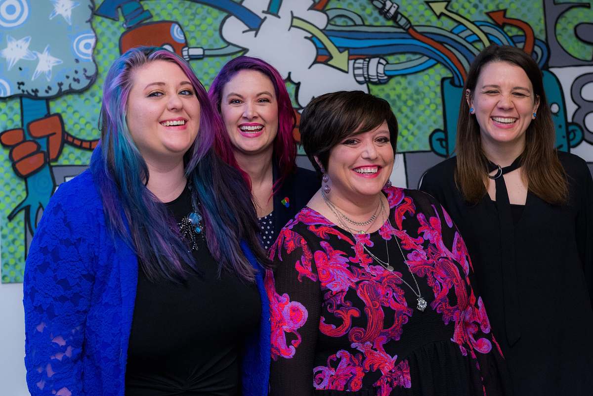 person four smiling womens standing inside room apparel