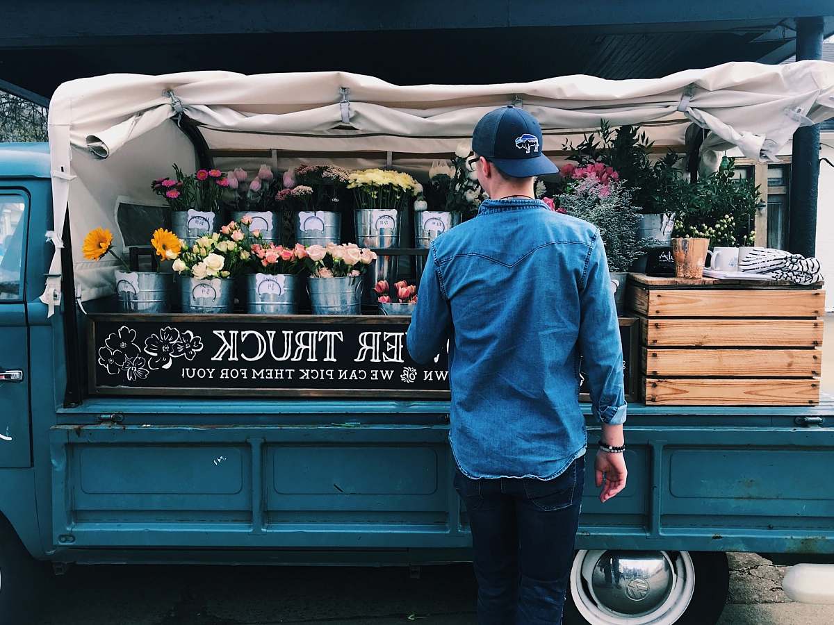 person man facing flower truck people