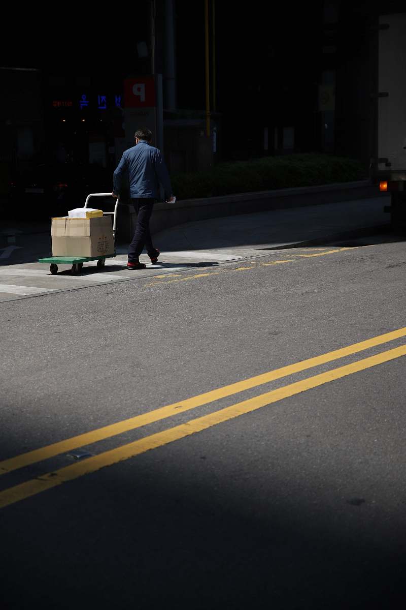 person man pulling trolley people