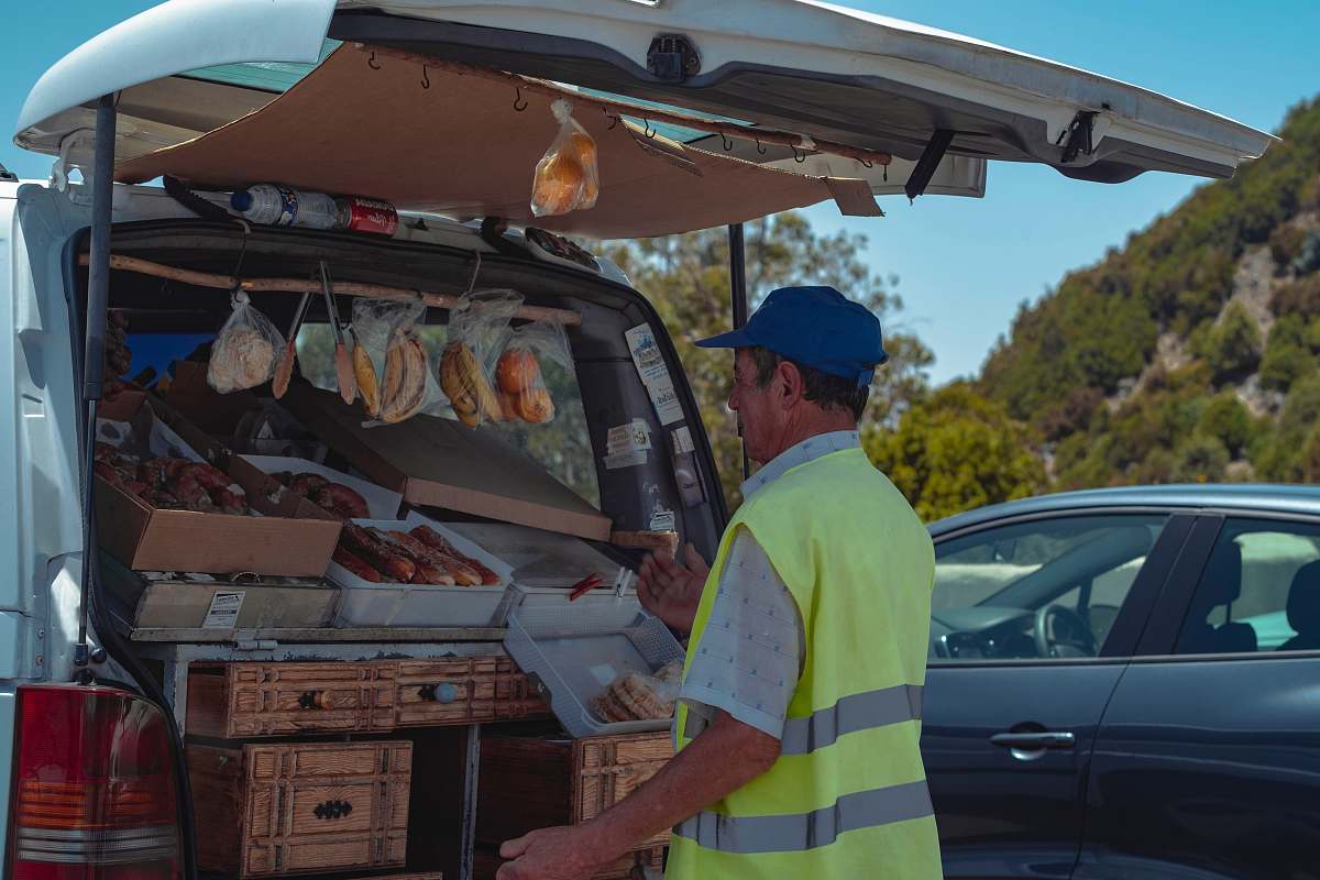 person man selling food using a vehicle trunk apparel
