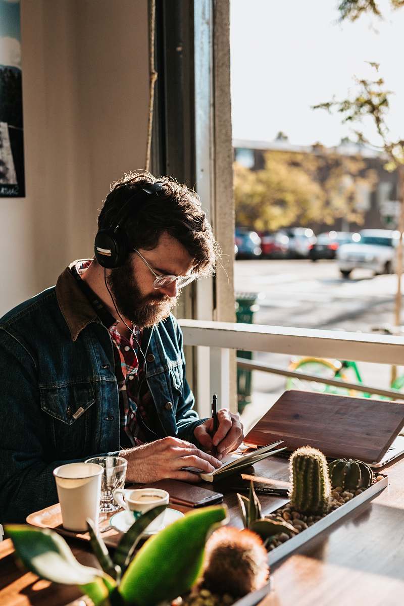 person man sitting on table in front of table wriing on paper people