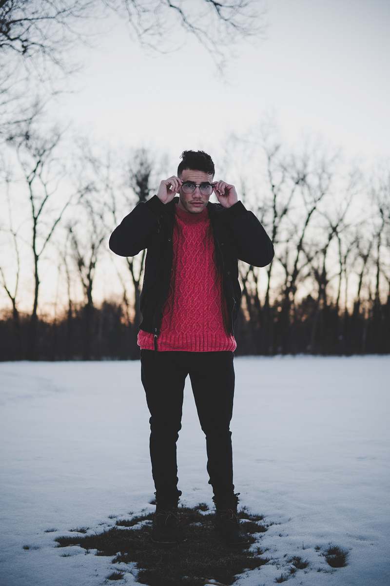 person man standing holding his eyeglasses people