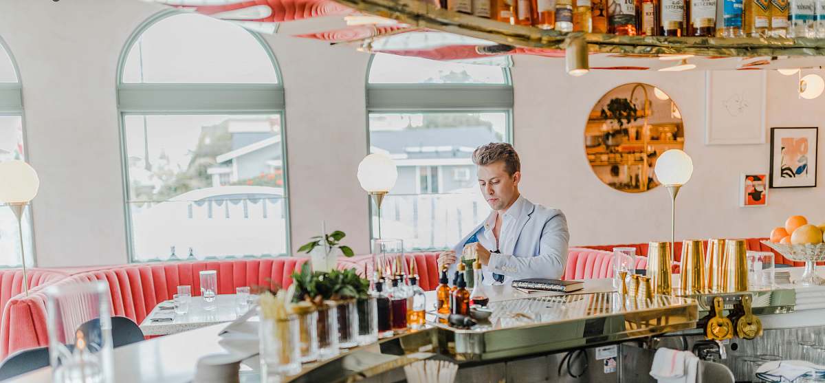 person man wearing gray suit standing beside counter restaurant