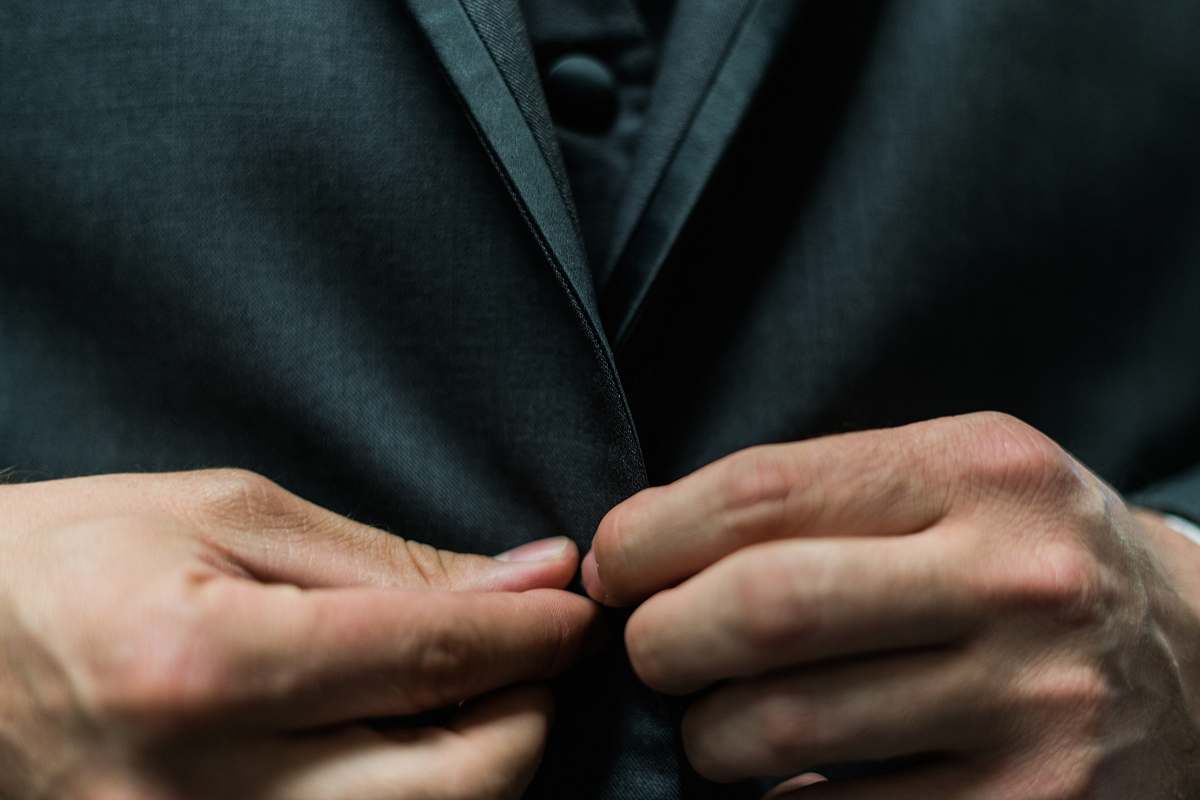 person person holding black suit jacket button suit