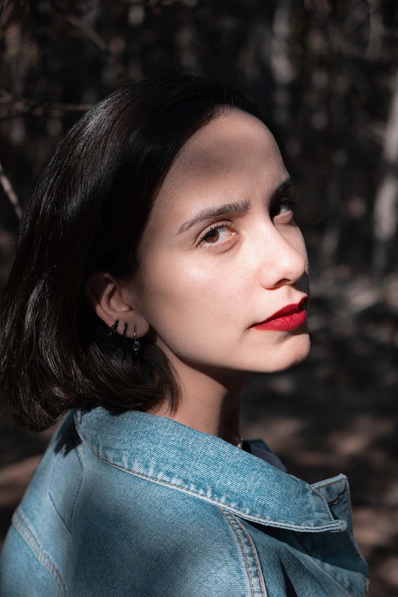 person selective focus photography of woman wearing blue denim collared top face