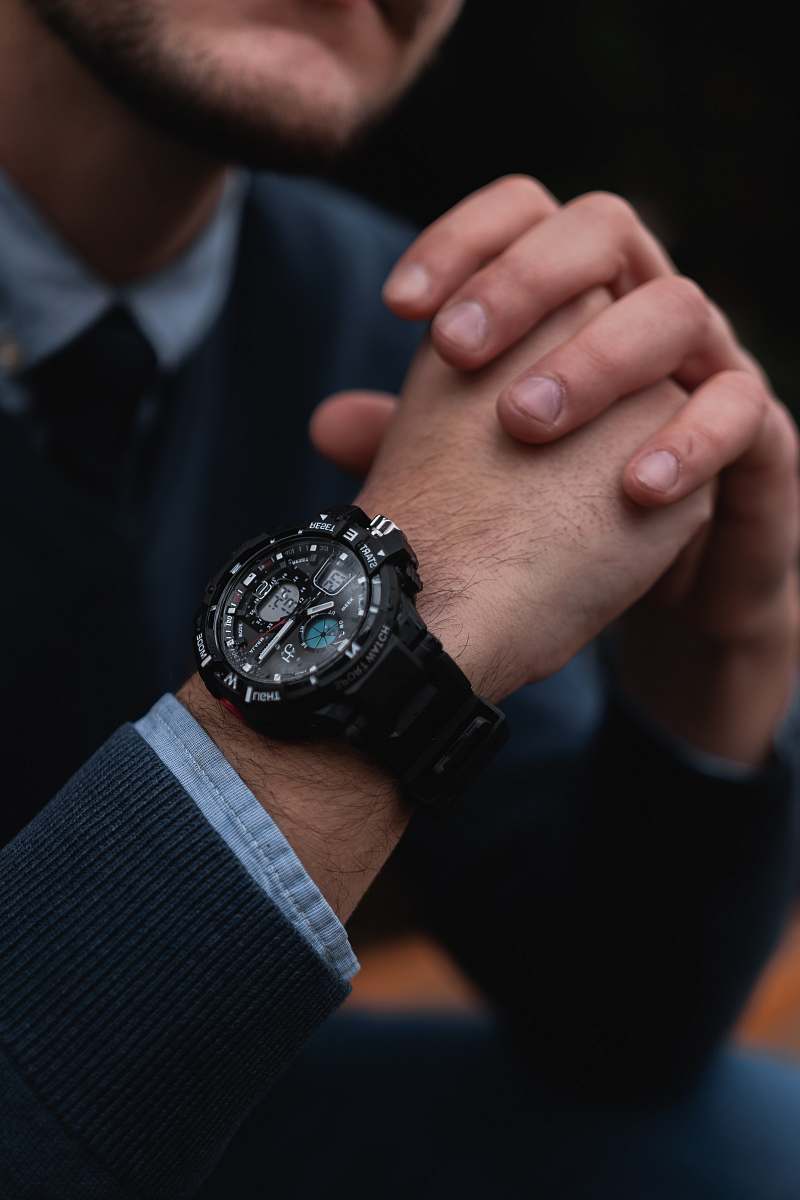 person shallow focus photo of person wearing round black chronograph watch wristwatch
