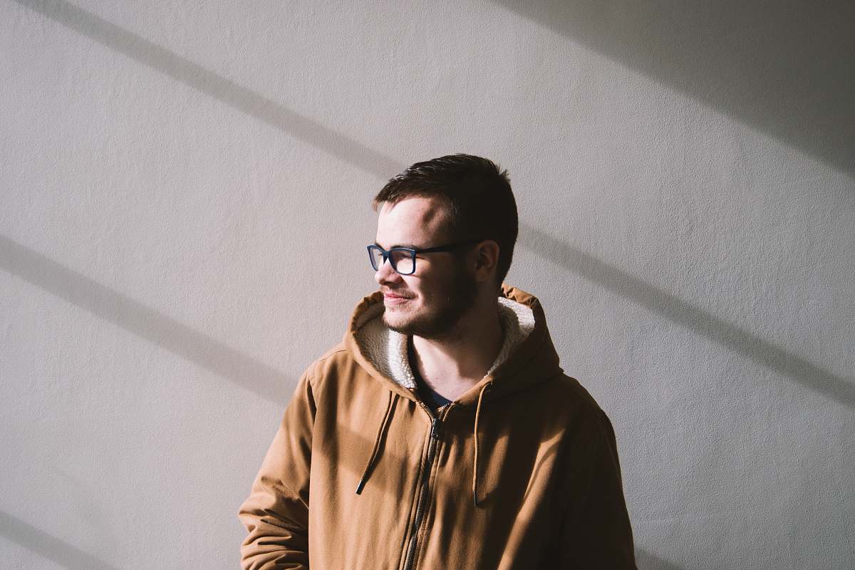 people smiling man standing near wall during daytime person