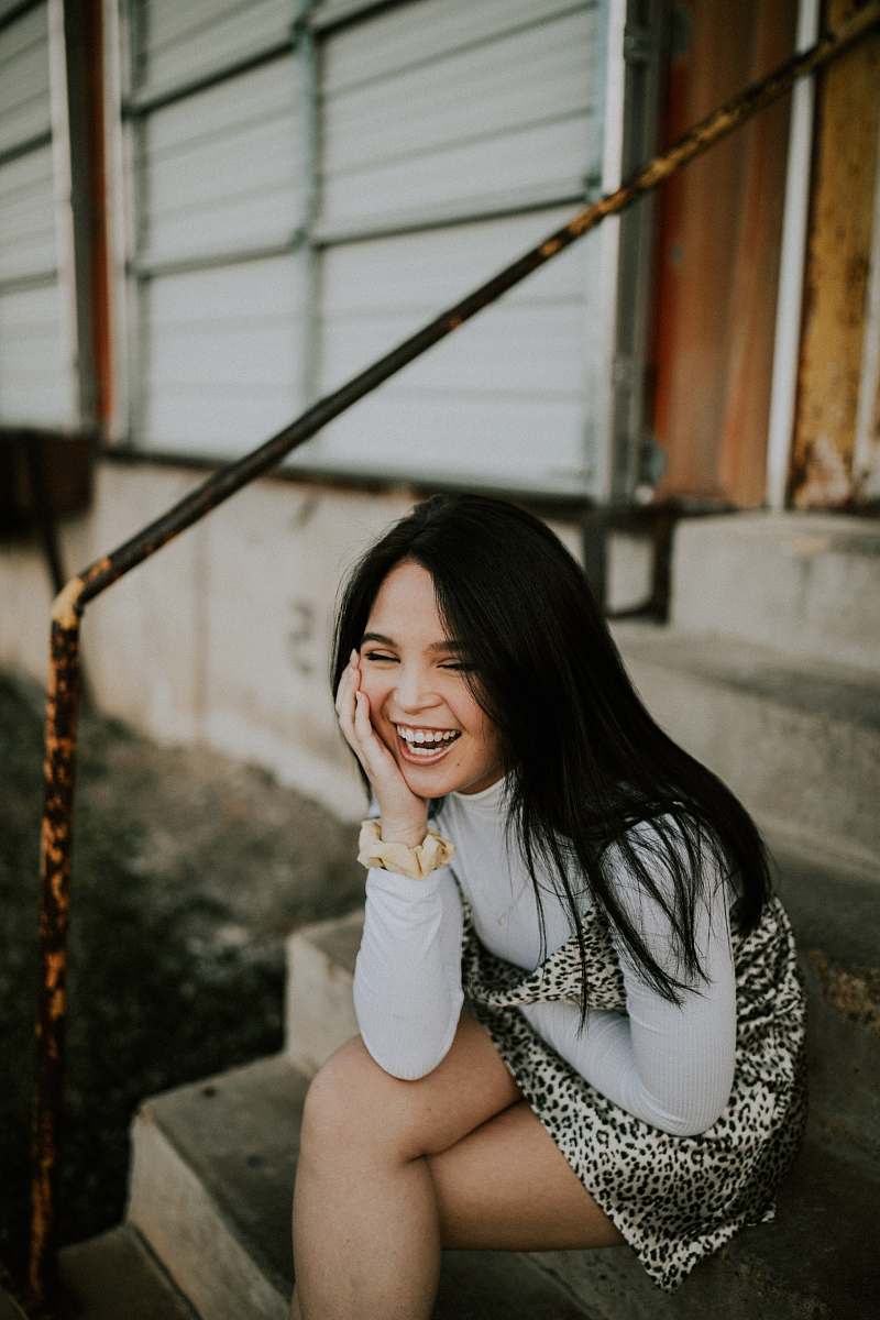 handrail smiling woman sitting on stairs banister