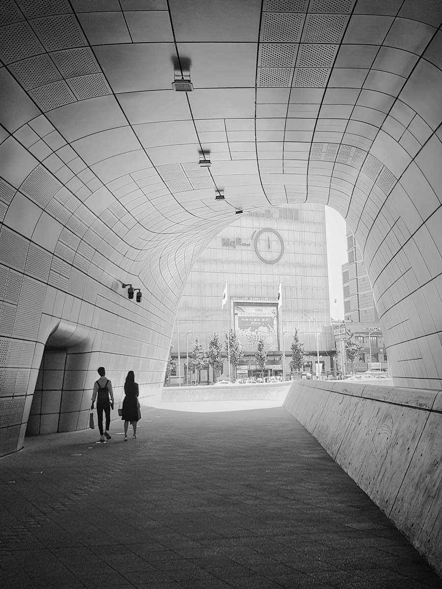 black-and-white white concrete tunnel during daytime grey