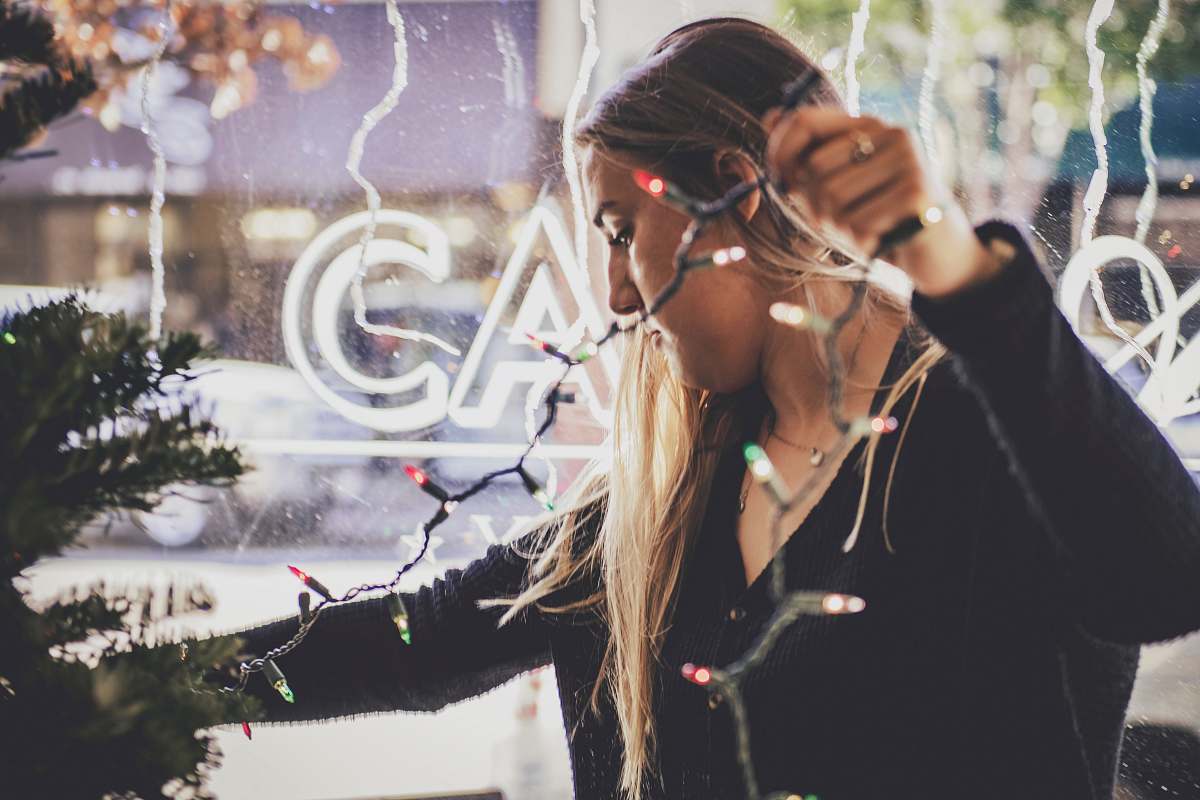 person woman holding string lights woman