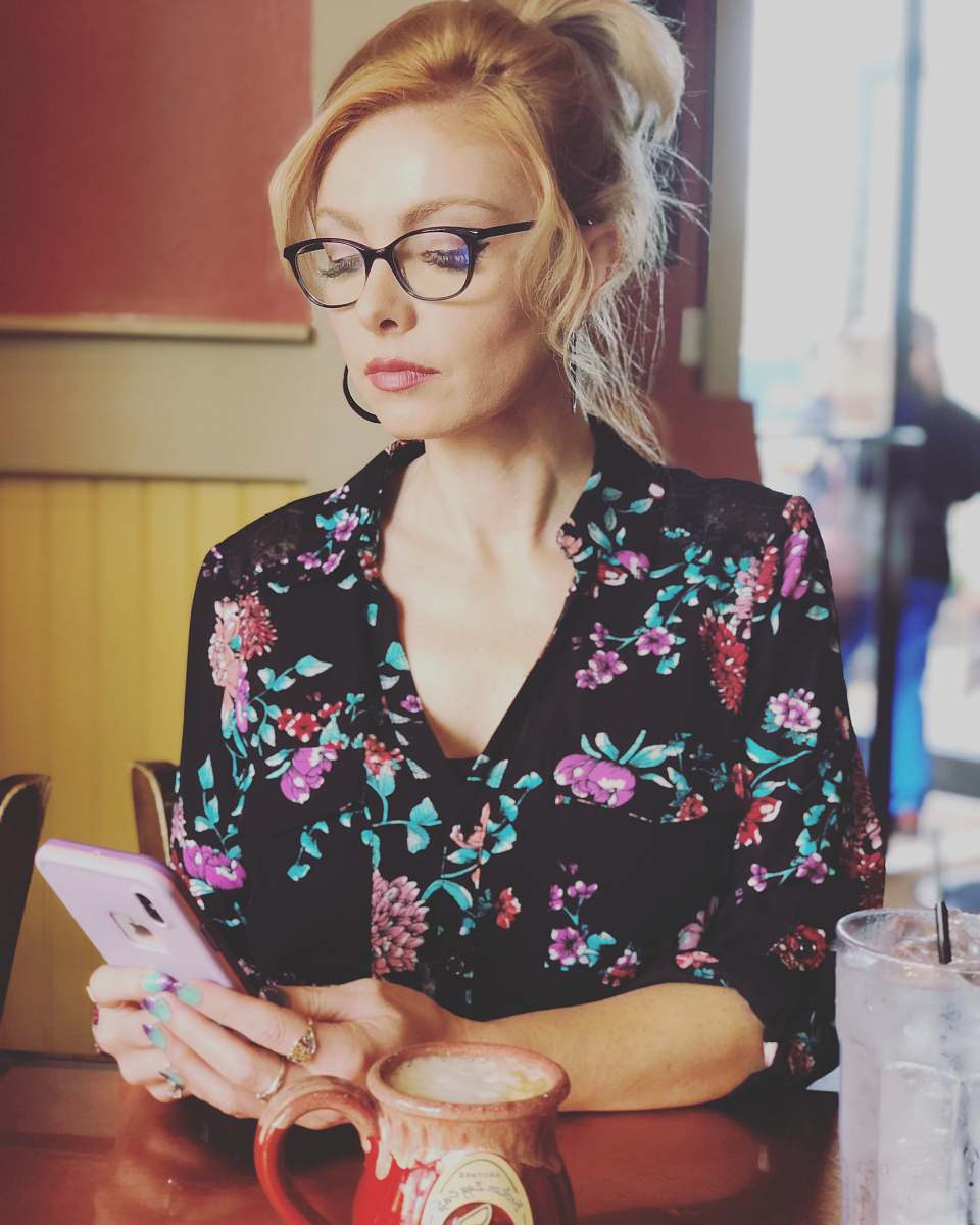 person woman looking at her phone glasses
