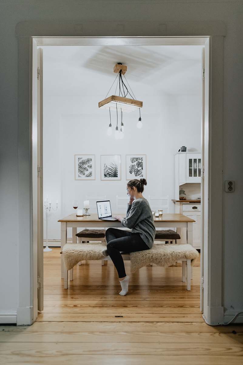person woman sitting on ottoman while leaning on table flooring