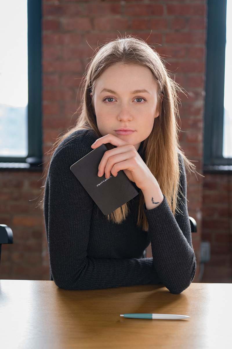 woman woman wearing black sweatshirt sitting beside table female