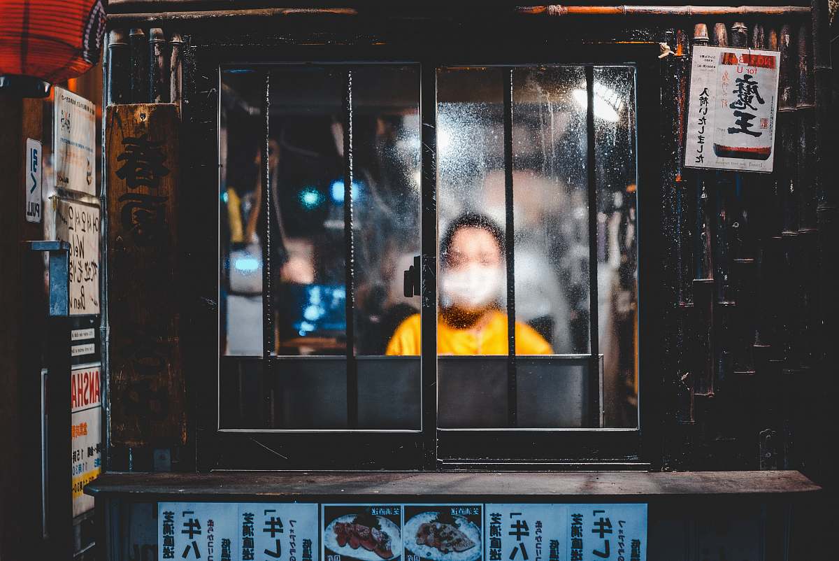 shinjuku boy standing in front of window poster