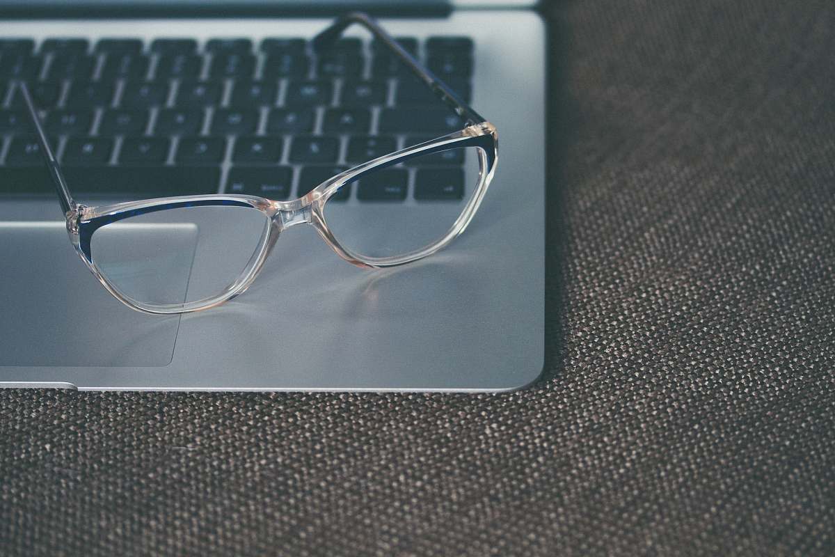 grey clear eyeglasses with black frames on laptop glasses