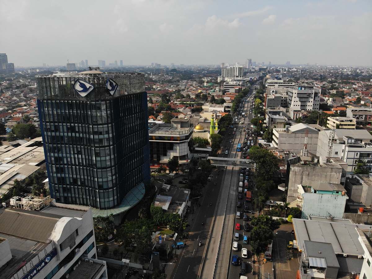 nature aerial photography of vehicle passing between buildings outdoors