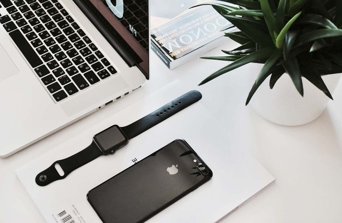 work space black stainless steel Apple Watch on table beside the MacBook Pro desk
