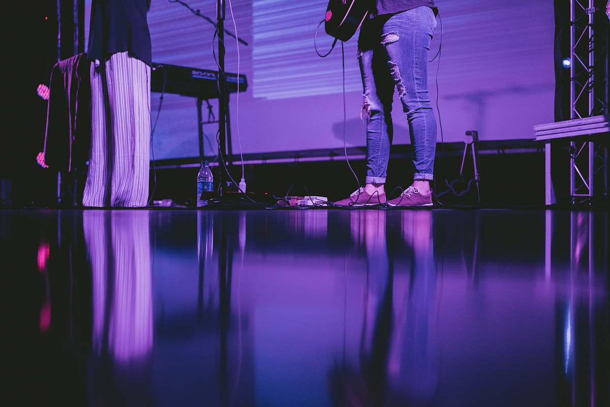 stage person playing guitar on stage band