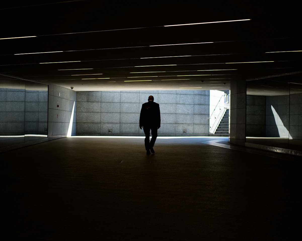 grey silhouette photo of person walking inside dark room piazza gae aulenti
