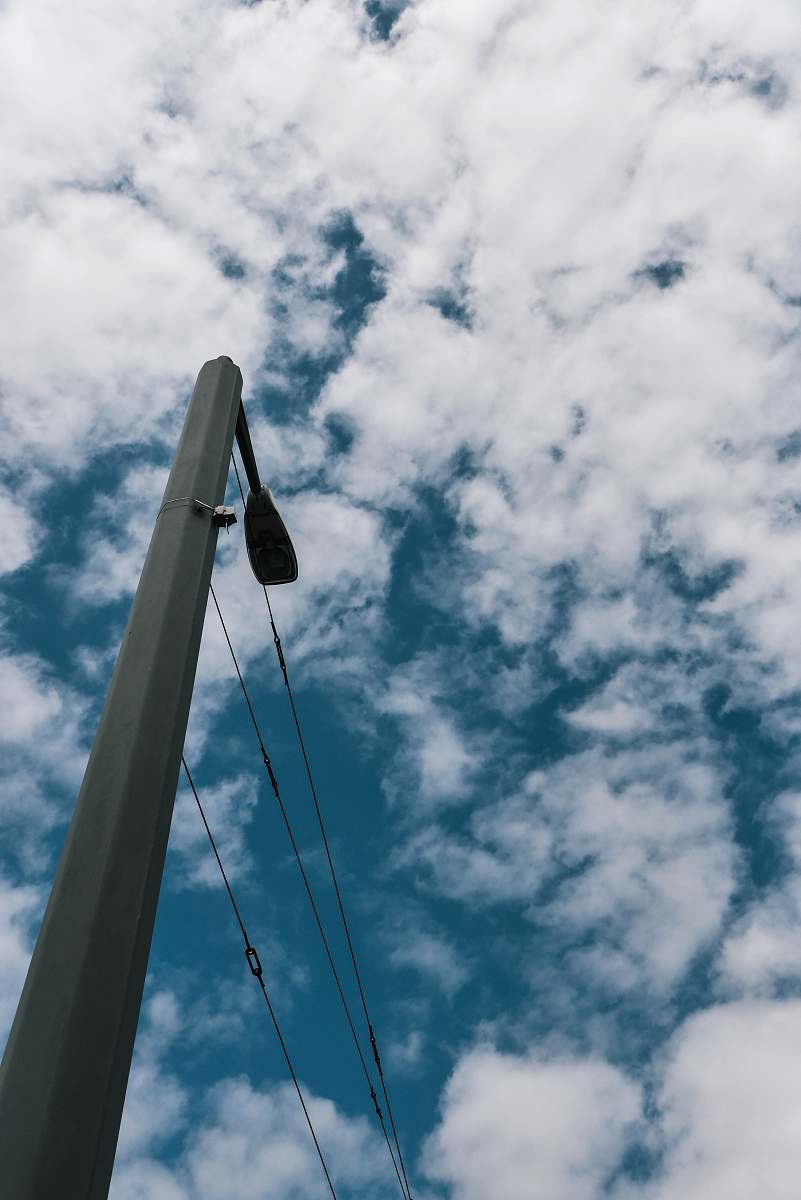sky grey concrete post under white clouds outdoors