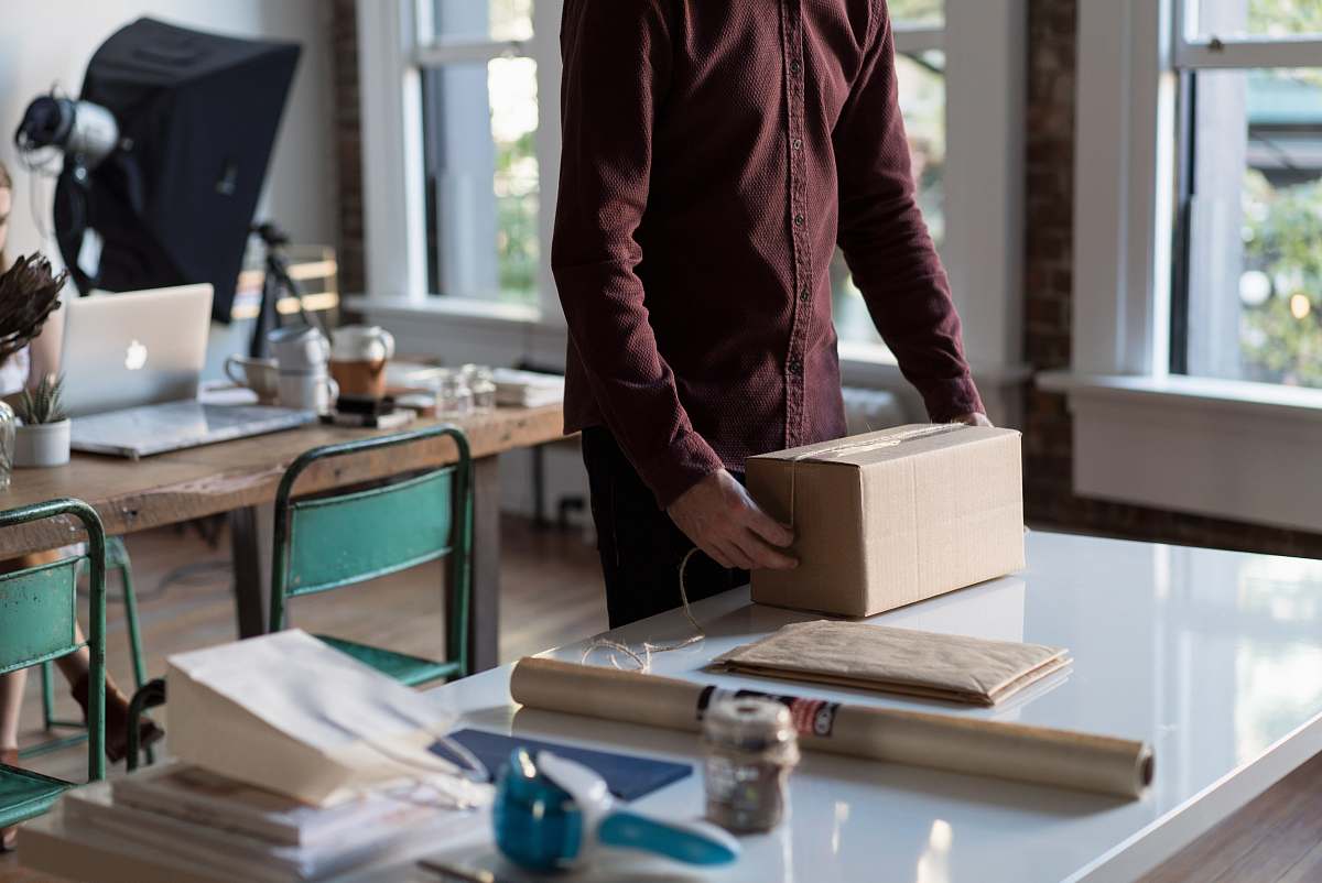 people person holding cardboard box on table person
